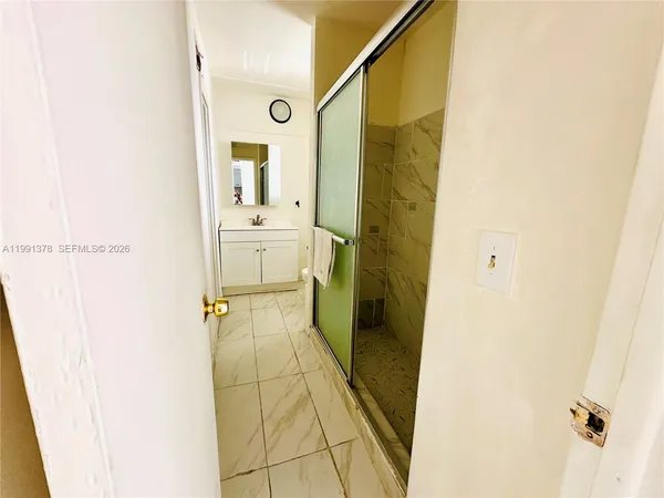 a bathroom with a shower and a glass door