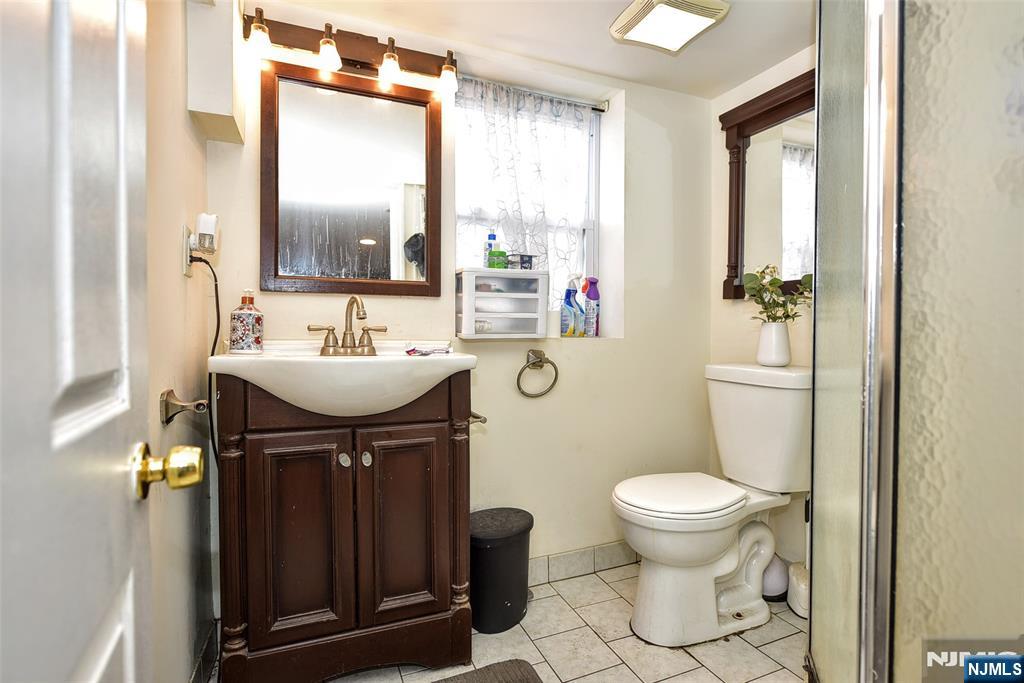 423 North 8th Street Fairview, NJ 07022 - Photo 12 of 30 a bathroom with a sink toilet and mirror