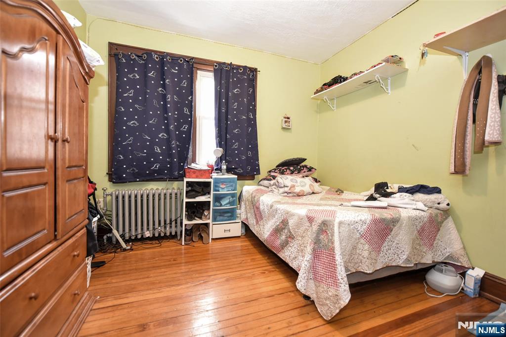 423 North 8th Street Fairview, NJ 07022 - Photo 27 of 30 a bed sitting in a bedroom next to a window