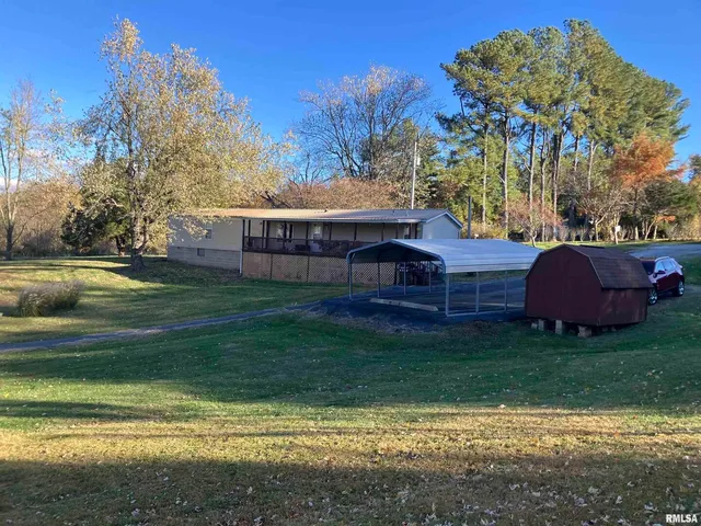 a view of a house with a yard and sitting area