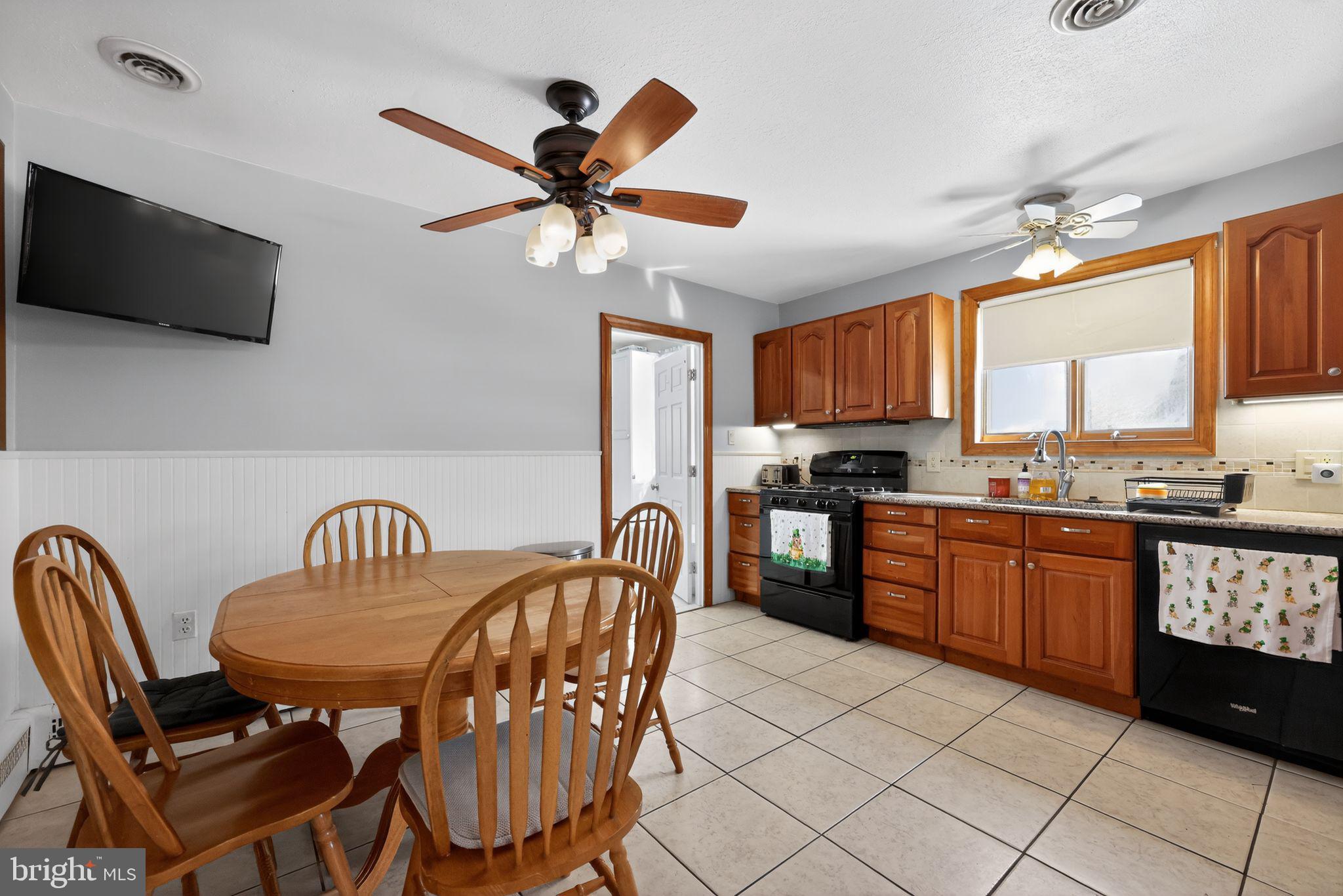 3206 Manor Road Huntingdon Valley, PA 19006 - Photo 15 of 37 a kitchen with stainless steel appliances granite countertop a stove a sink dishwasher a dining table and chairs with wooden floor