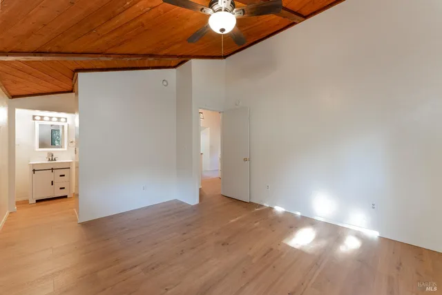 a view of a livingroom with wooden floor and a ceiling fan