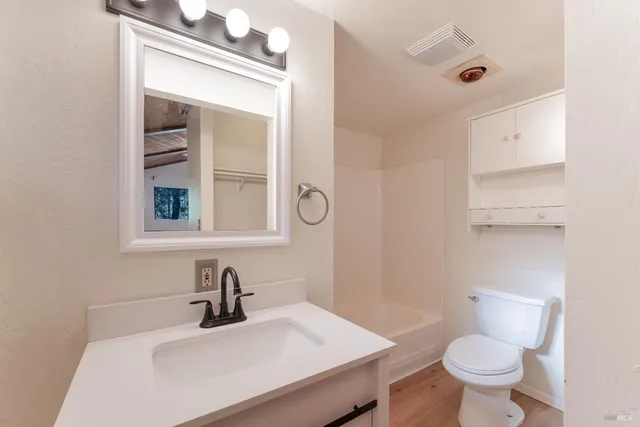 a bathroom with a sink a toilet and a mirror