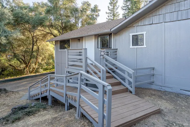 a view of a house with wooden deck and a backyard