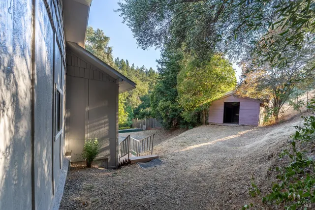 a view of a house with backyard and trees