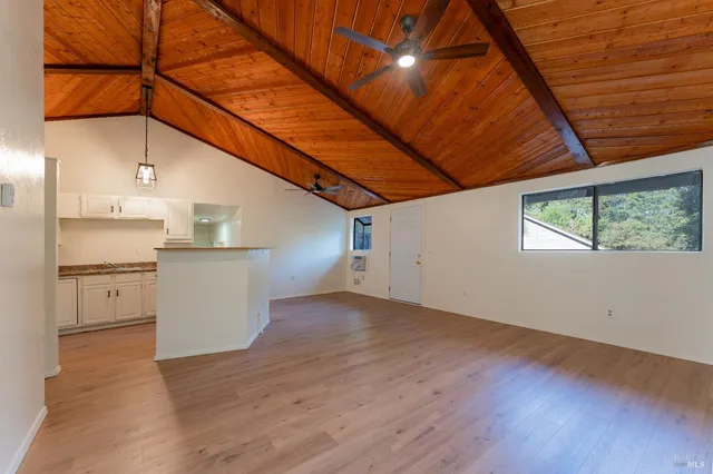 a view of a kitchen with wooden floor and a refrigerator