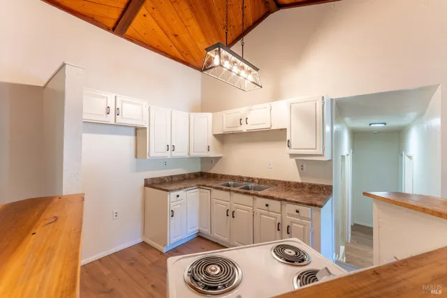 a kitchen with granite countertop a sink a stove and refrigerator