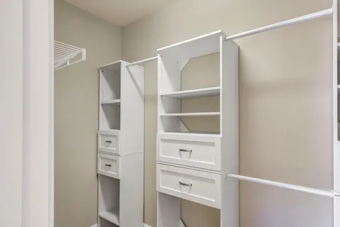 a view of walk in closet with empty racks