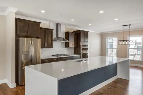 a large kitchen with stainless steel appliances a refrigerator a stove and a sink