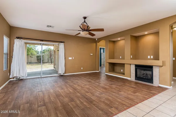 a view of empty room with wooden floor and fireplace