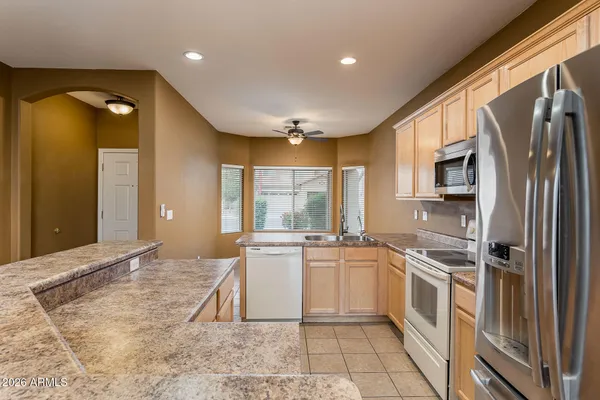 a kitchen with stainless steel appliances granite countertop a stove a sink and a refrigerator