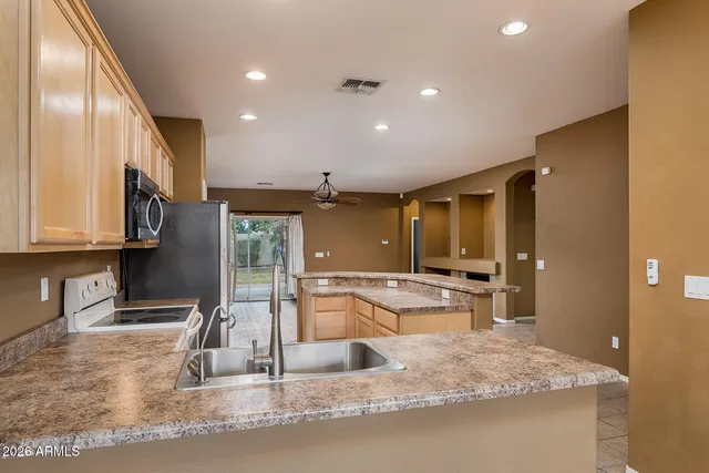 a kitchen with kitchen island granite countertop a large counter top stainless steel appliances and cabinets