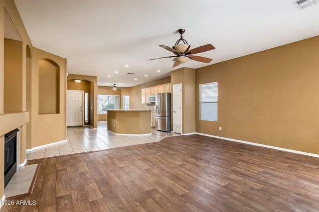a view of a livingroom with a ceiling fan wooden floor and a ceiling fan
