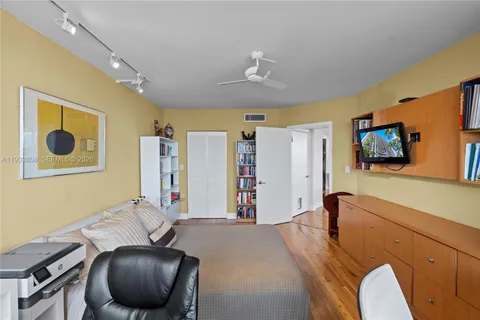 a view of a kitchen with kitchen island a large counter top space a sink stainless steel appliances and cabinets