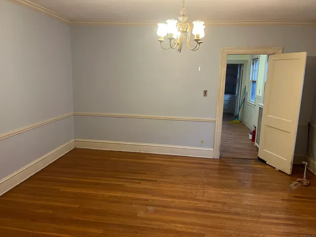 a view of a room with wooden floor and a ceiling fan