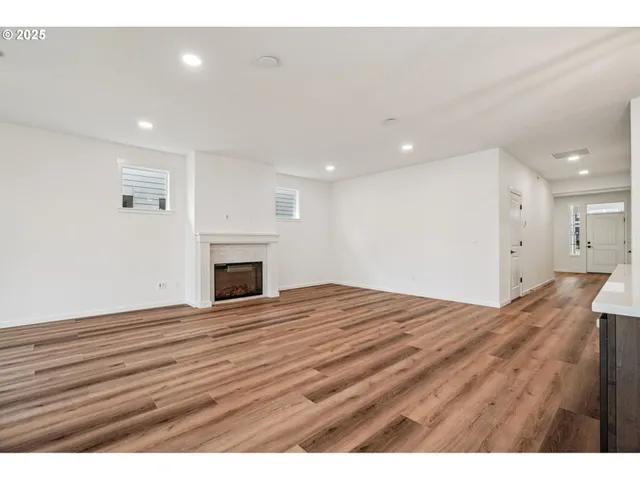 a view of empty room with wooden floor and fireplace