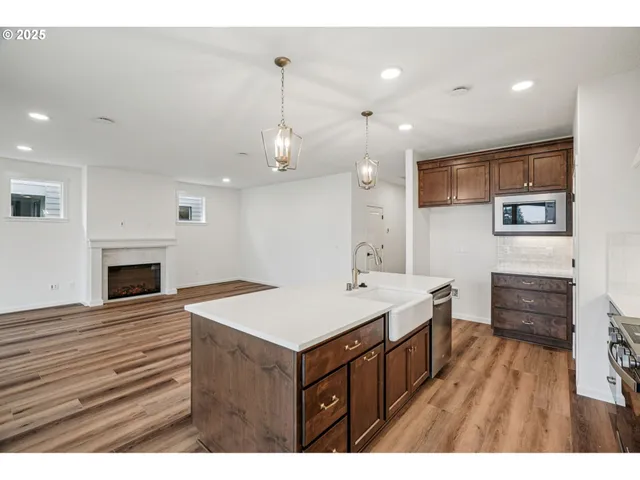 a kitchen that has a lot of cabinets and wooden floor