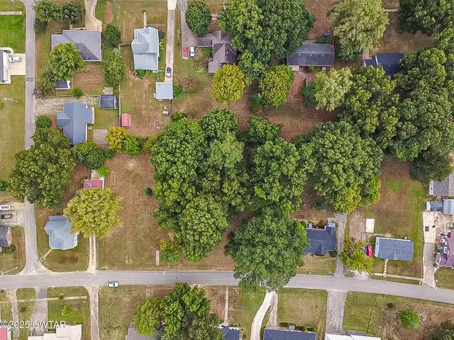 an aerial view of residential houses with outdoor space and street view