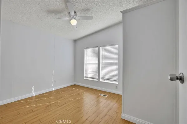 an empty room with a window and a ceiling fan