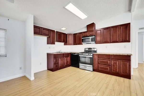 a kitchen with stainless steel appliances granite countertop a stove refrigerator and a sink
