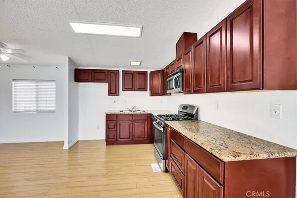 a kitchen with stainless steel appliances granite countertop a stove sink and cabinets