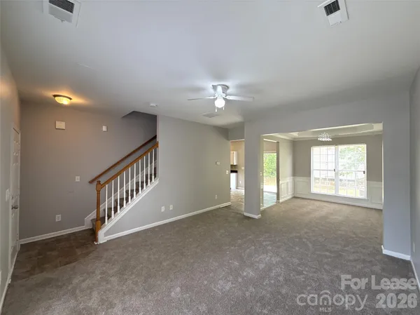 an empty room with windows and fan
