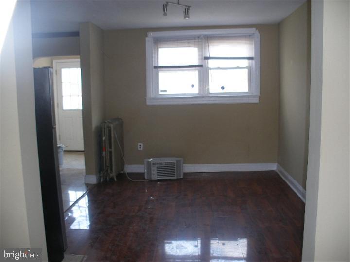 555 Millbank Road Upper Darby, PA 19082 - Photo 4 of 14 an empty room with wooden floor and a window