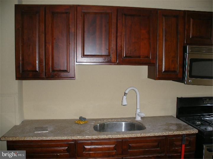 555 Millbank Road Upper Darby, PA 19082 - Photo 5 of 14 a kitchen with granite countertop wood cabinets and a sink