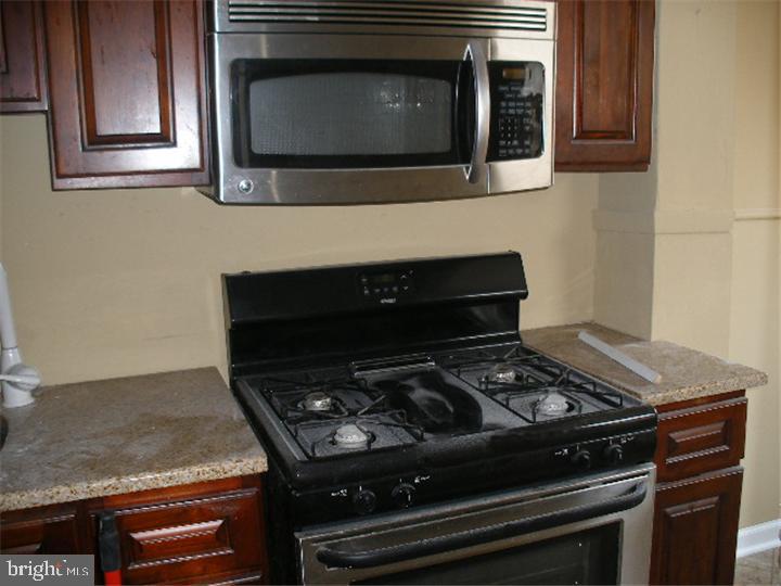 555 Millbank Road Upper Darby, PA 19082 - Photo 6 of 14 a kitchen with a stove and a microwave