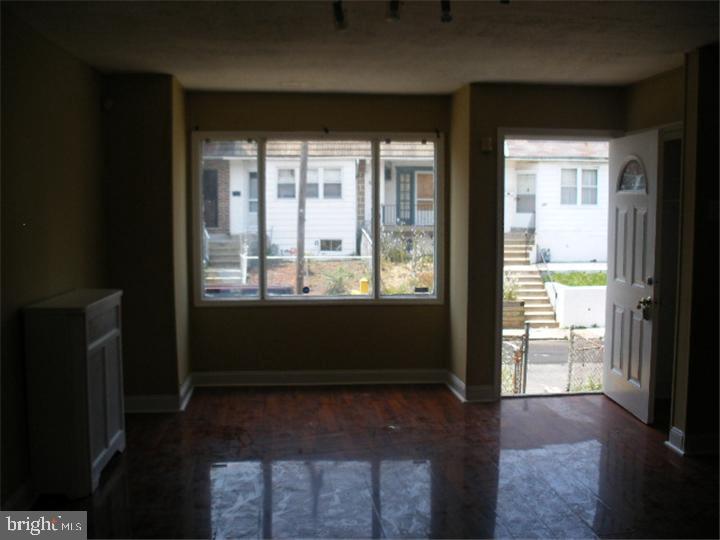 555 Millbank Road Upper Darby, PA 19082 - Photo 8 of 14 a view of empty room with wooden floor and fan