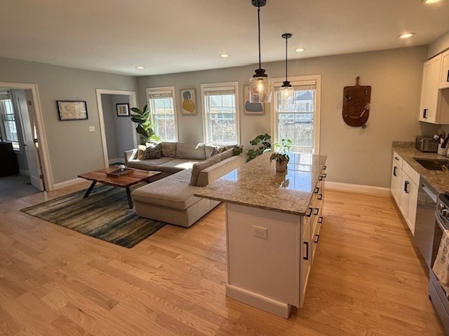 4 Cushing Street, Unit A Amesbury, MA 01913 - Photo 4 of 19 a living room with granite countertop furniture and a flat screen tv