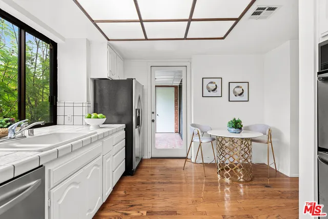 a spacious bathroom with a granite countertop sink a toilet a mirror and shower
