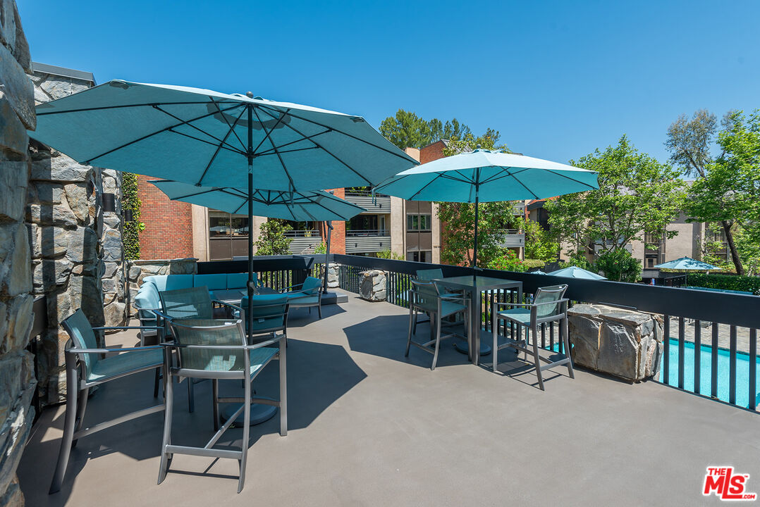 4736 Park Encino Lane, Unit 215 Encino, CA 91436 - Photo 28 of 37 a view of balcony with chairs and umbrella