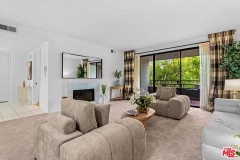 a living room with furniture large window and a fireplace