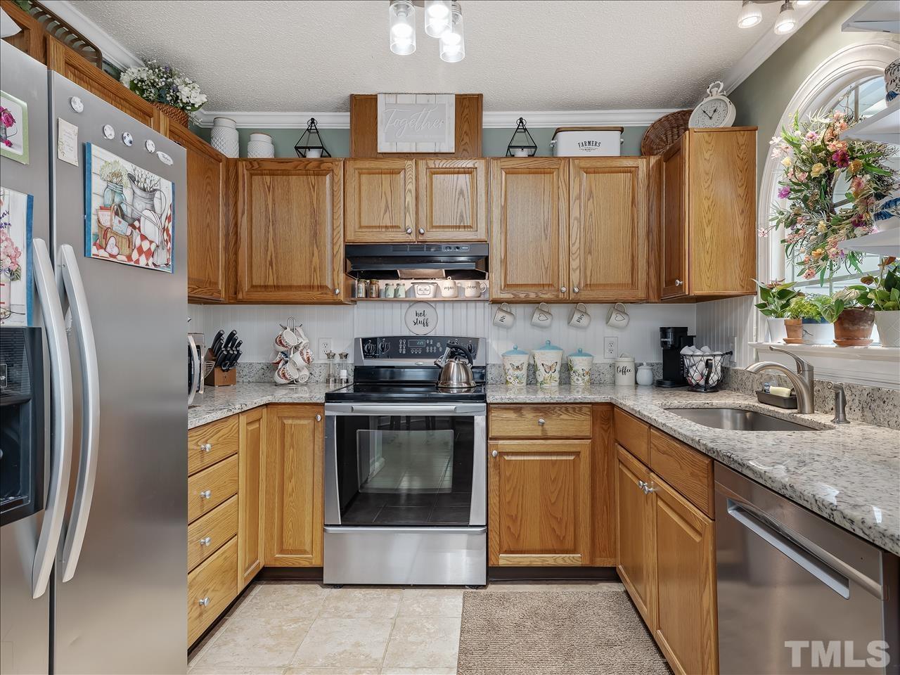 4408 Emmit Drive Raleigh, NC 27604 - Photo 36 of 38 a kitchen with stainless steel appliances granite countertop a stove sink and refrigerator