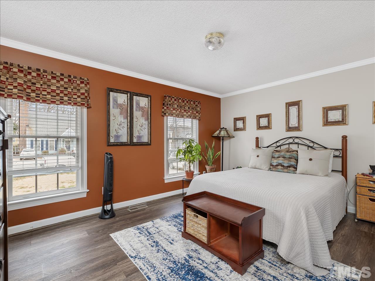 4408 Emmit Drive Raleigh, NC 27604 - Photo 5 of 38 a bedroom with a bed a dresser next to a window