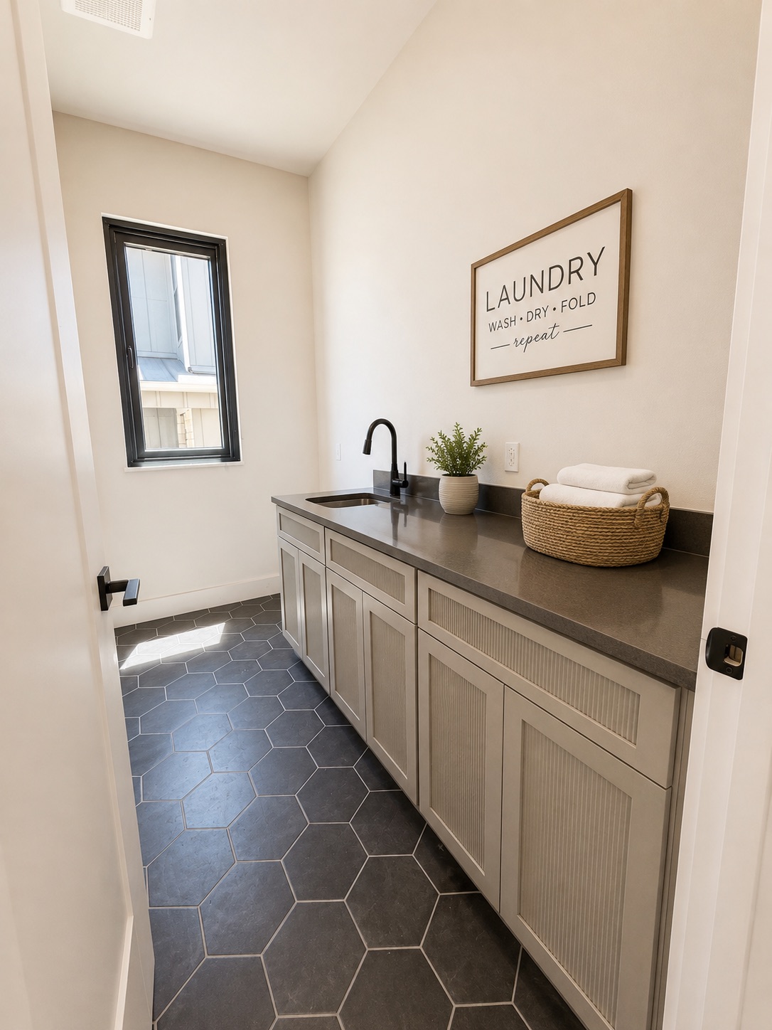 711 Paleface Ranch Road, Unit 4 Spicewood, TX 78669 - Photo 8 of 14 A well-appointed laundry area features practical counter space, an integrated sink, and hexagon tile flooring.