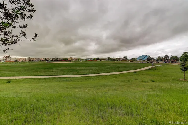 a view of a field with houses in background