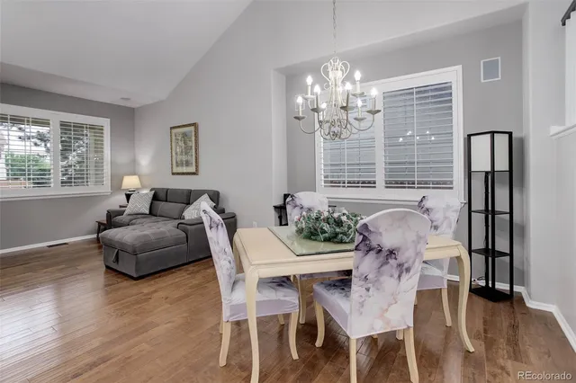 a dining room with furniture a chandelier and wooden floor