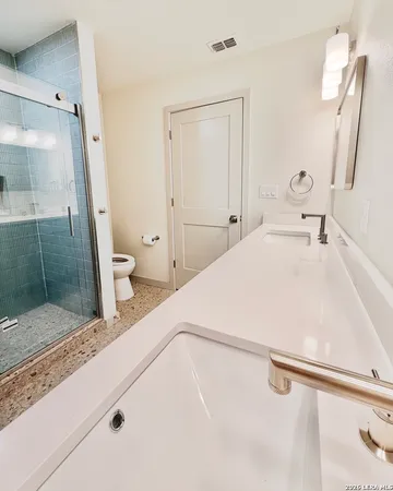 a bathroom with a sink a toilet and a shower