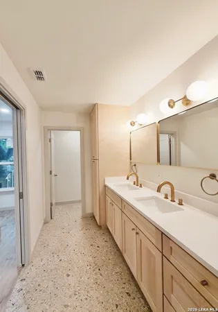 a spacious bathroom with a double vanity sink and mirror