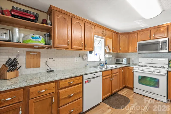 a kitchen with granite countertop a sink stainless steel appliances and cabinets