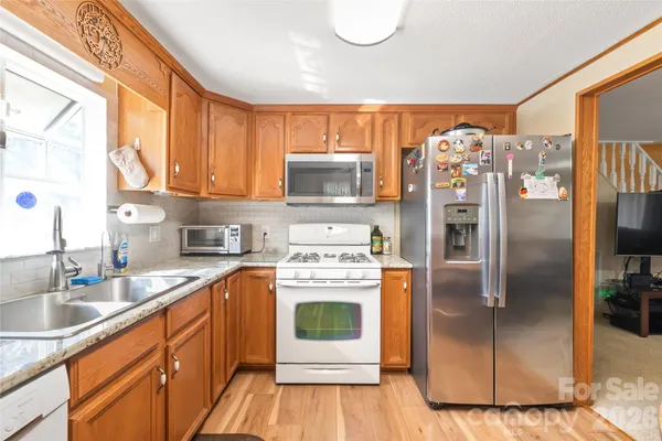a kitchen with stainless steel appliances a stove a sink and a refrigerator