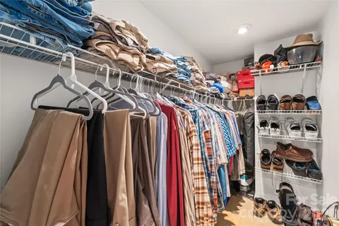 a view of walk in closet with clothes and shoes