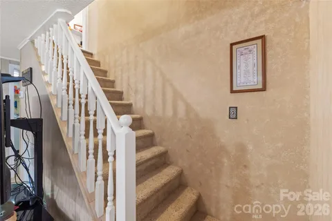 a view of staircase with wooden floor and white walls
