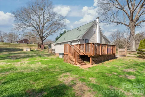 a view of a house with backyard and a tree