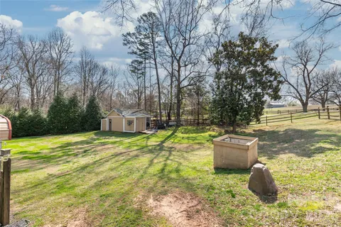 a backyard of a house with fountain table and chairs