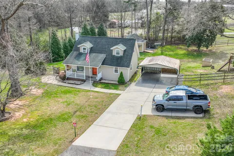 a car parked in front of a brick house with large trees