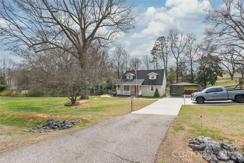 a view of a swimming pool with a yard and large trees