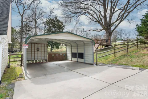 a view of a house with a large tree and a yard